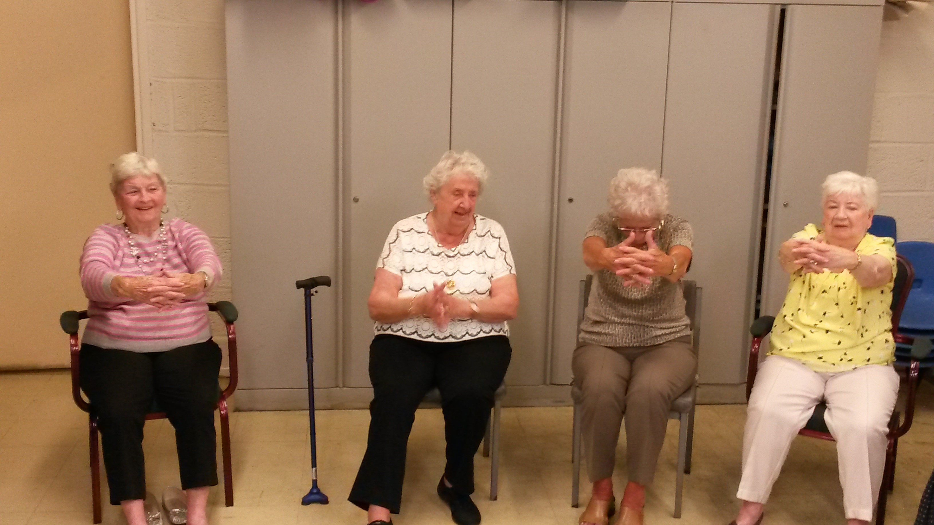 Older women partaking in seated yoga