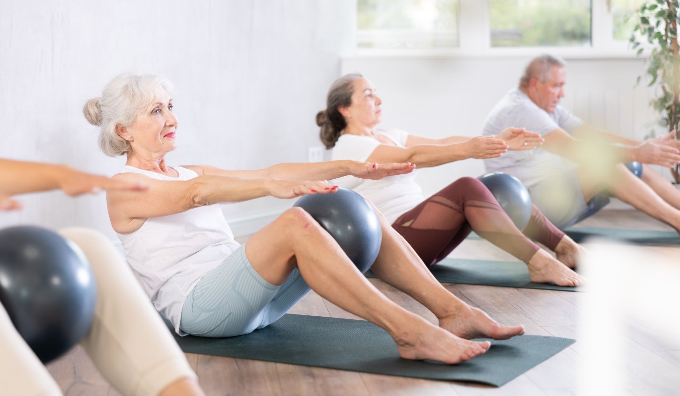 A group of older adults exercising on mats