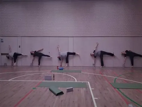 A group of women stretching with their left arms and legs off the floor 