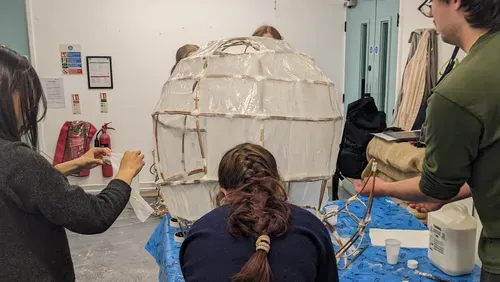 Group of young people and facilitator creating a willow sculpture