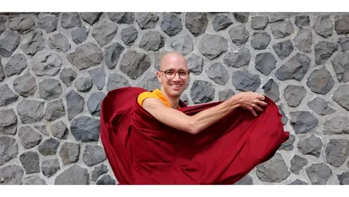 the facilitator, a Buddhist monk, waving his robe in the wind