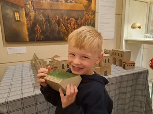 A young boy playing with the model fort in the museum