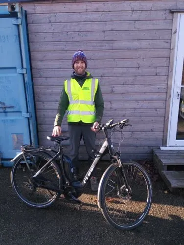 Tom standing with a bike in front of the ebike shelter