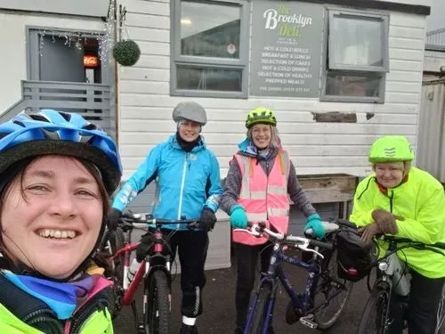 4 women cyclists all smiling