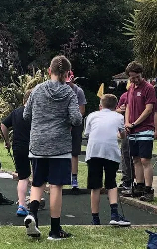young people playing mini golf