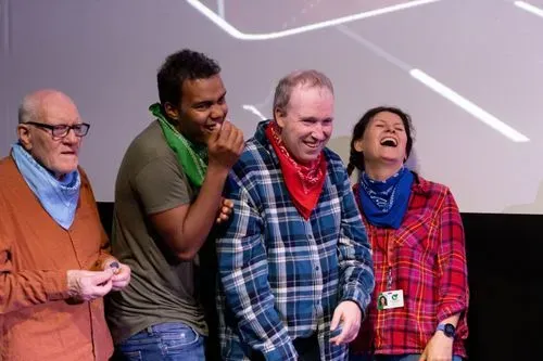 Three men and one women performing on stage 