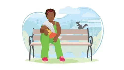 Woman sat on bench feeding baby.