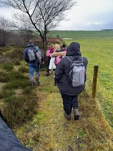 people walking down grass footpath in walking gear