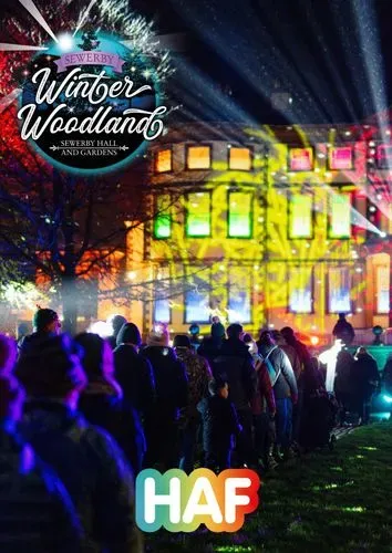 Sewerby Hall lit up with people walking