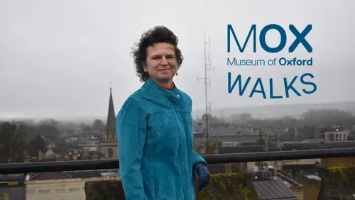 Tour guide Liz Woolley wearing a blue jacket, with the Oxford skyline in the background