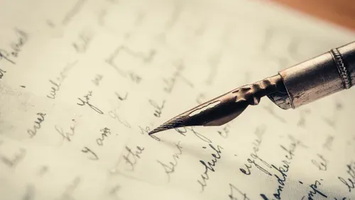 A close-up of a fountain pen and a page with words in black ink