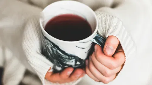 image of hands holding a cup of herbal tea