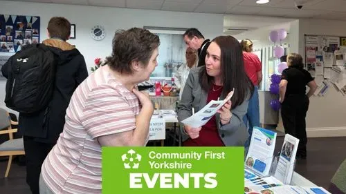 People talking at a community information stand with leaflets at a Community First Yorkshire events stall
