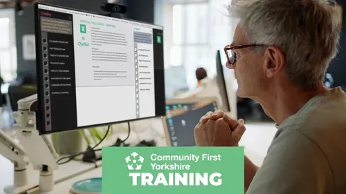 Person sitting at a desk looking at a computer monitor displaying an AI chatbot interface with text and options. Green banner reads “Community First Yorkshire TRAINING.”