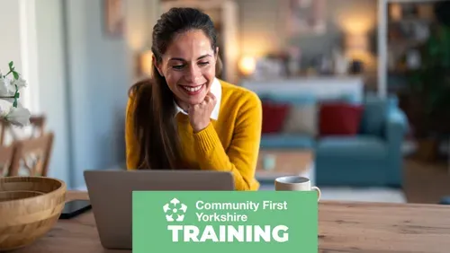 Woman smiling at her laptop during an online session, with Community First Yorkshire Training branding.