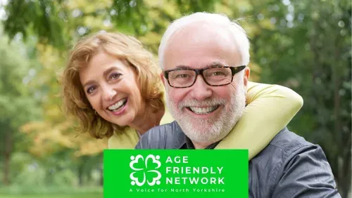 Two older adults are outdoors in a green park setting, with one person standing behind the other and both facing the camera. The image includes the Age Friendly Network logo and the text: “Age Friendly Network – A Voice for North Yorkshire.”