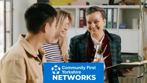 Three people chatting at a network meeting, with blue Community First Yorkshire Networks branding.