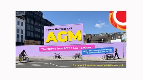 Photograph of a light purple billboard in Shoreditch. One person is cycling and one person is walking. Bikes are parked on the street. Text on the billboard: Tower Hamlets CVS AGM (in bright yellow) Thursday 5 June / 4.40 to 6.00pm / St Hilda's Community Centre, 18 Club Row London, E2 7EY written in pink and blue boxes. THCVS logo in the top right corner. For more information, email info@thcvs.org.uk.