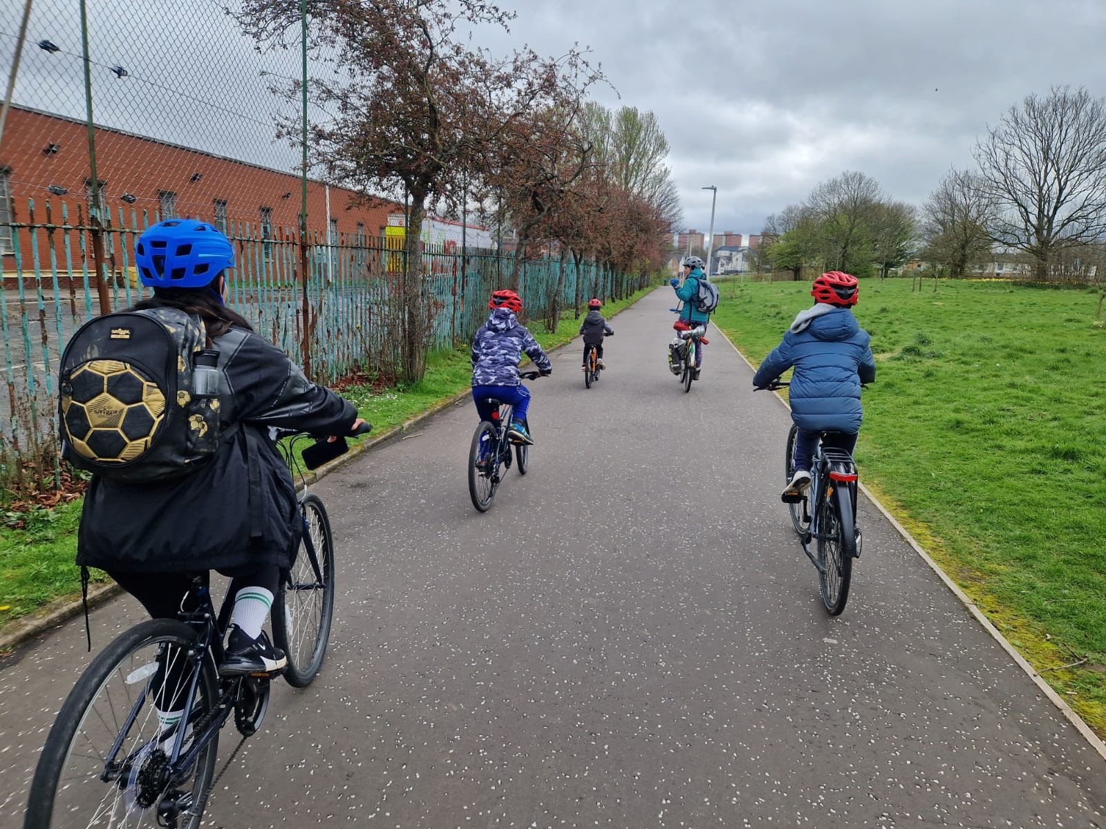Kids and parent cycling along a path seen from behind