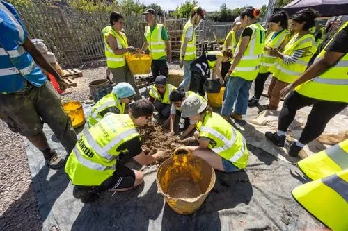 Multiple people helping to mix cob