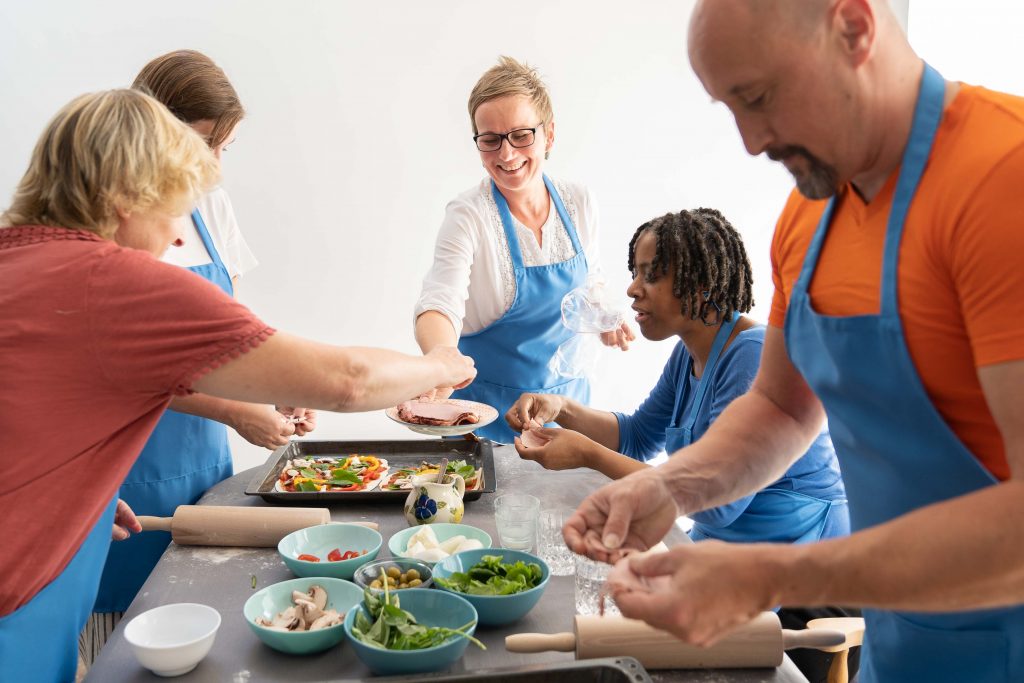 An image of people sharing food together over a kitchen table. 